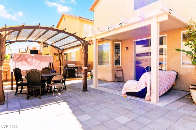 view of patio with area for grilling, a pergola, outdoor dining area, and fence