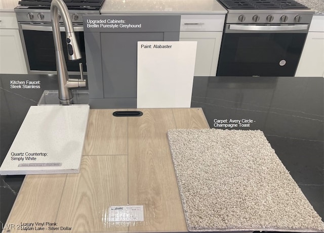 interior space with stainless steel range with gas stovetop, white cabinets, and light countertops