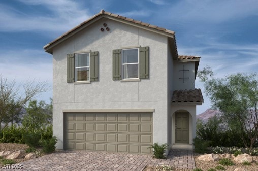 mediterranean / spanish-style home featuring stucco siding, decorative driveway, a garage, and a tiled roof