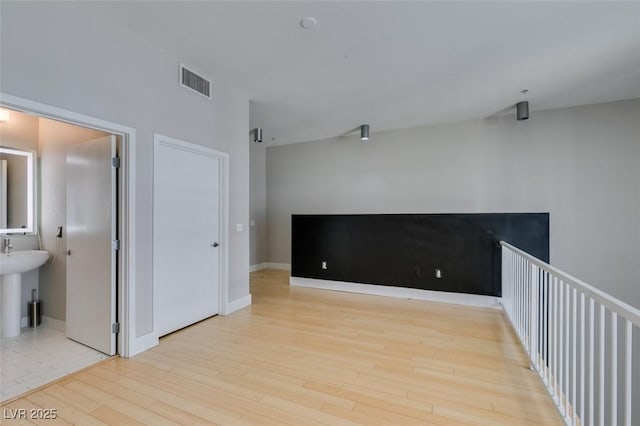 empty room featuring visible vents, baseboards, and wood finished floors