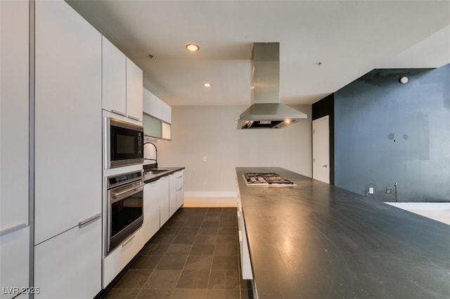 kitchen featuring modern cabinets, dark countertops, range hood, stainless steel appliances, and white cabinets