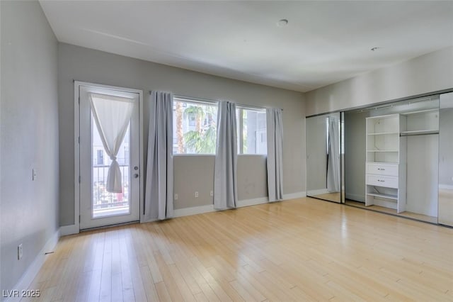 unfurnished bedroom featuring light wood-type flooring and baseboards