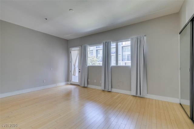 empty room with baseboards and light wood finished floors