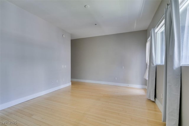 spare room with light wood-style floors and baseboards