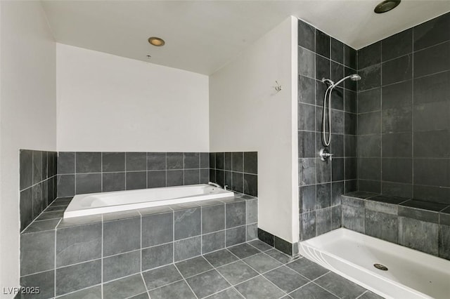 bathroom featuring tile patterned floors, a relaxing tiled tub, and a tile shower