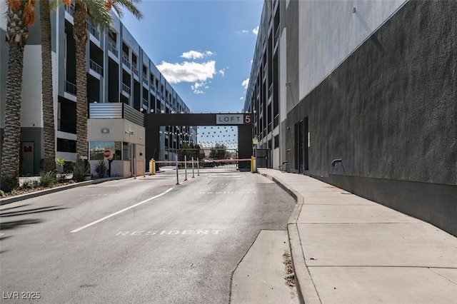 view of street featuring a gated entry and curbs