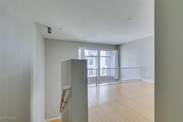 unfurnished room featuring light wood finished floors and baseboards