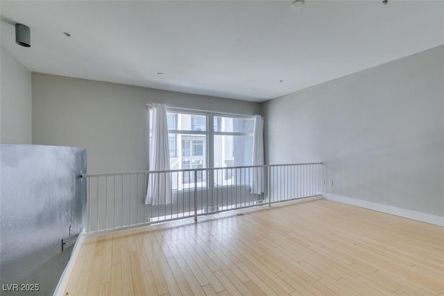 unfurnished room featuring wood finished floors and baseboards