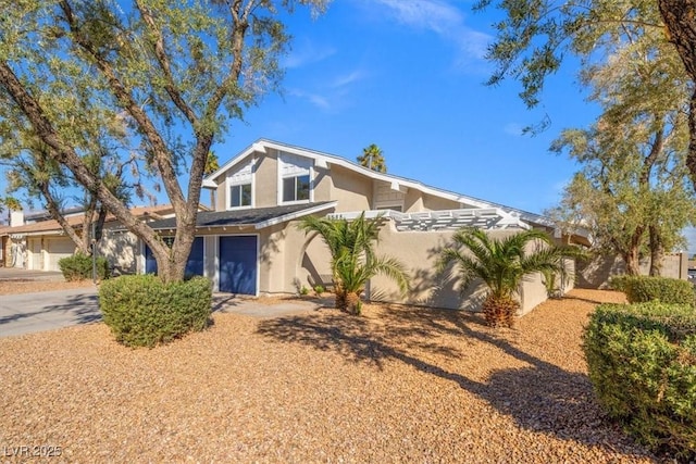 view of front facade featuring stucco siding, driveway, and a garage