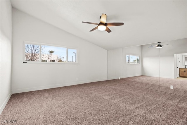 carpeted spare room featuring baseboards, lofted ceiling, and a ceiling fan