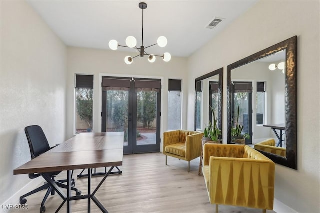 dining area featuring visible vents, baseboards, french doors, an inviting chandelier, and light wood-style floors