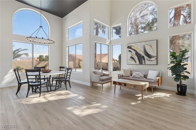 dining space featuring a notable chandelier, wood finished floors, and baseboards