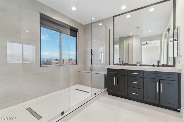 bathroom with a walk in shower, a sink, recessed lighting, double vanity, and ceiling fan