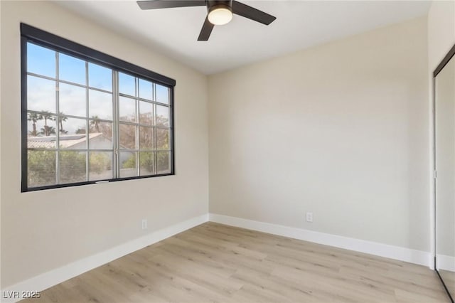 unfurnished room featuring light wood-style flooring, a ceiling fan, and baseboards