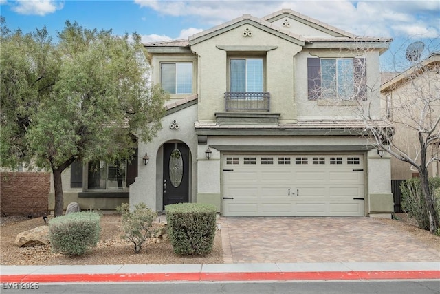 view of front of property with fence, a tile roof, stucco siding, decorative driveway, and a garage