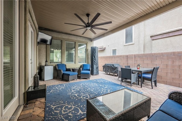 view of patio / terrace with outdoor dining space, an outdoor living space, ceiling fan, and fence