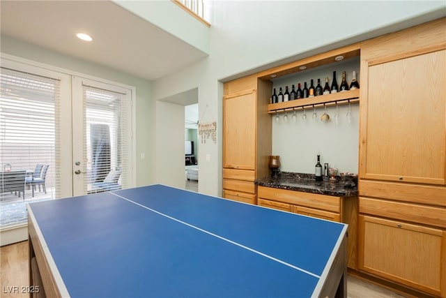 recreation room with a bar, recessed lighting, french doors, and light wood-type flooring