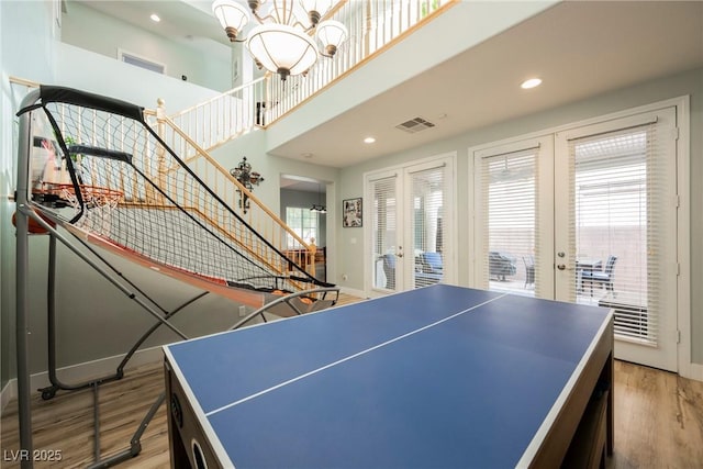 recreation room featuring light wood-style flooring, plenty of natural light, french doors, and visible vents