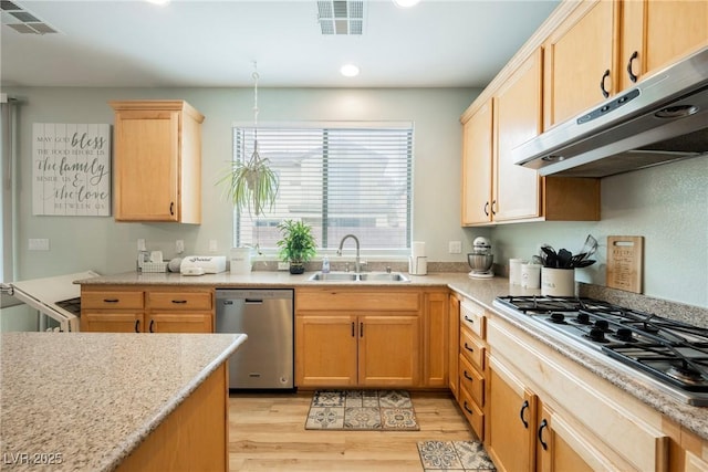 kitchen with visible vents, a sink, stainless steel appliances, light wood-style floors, and under cabinet range hood