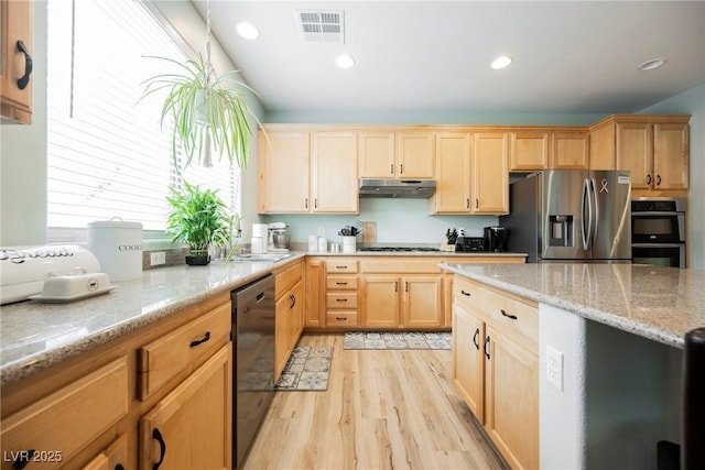 kitchen with light wood-type flooring, visible vents, under cabinet range hood, light stone counters, and stainless steel appliances