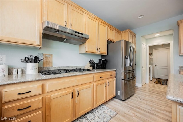 kitchen featuring appliances with stainless steel finishes, light brown cabinets, light wood-type flooring, and under cabinet range hood