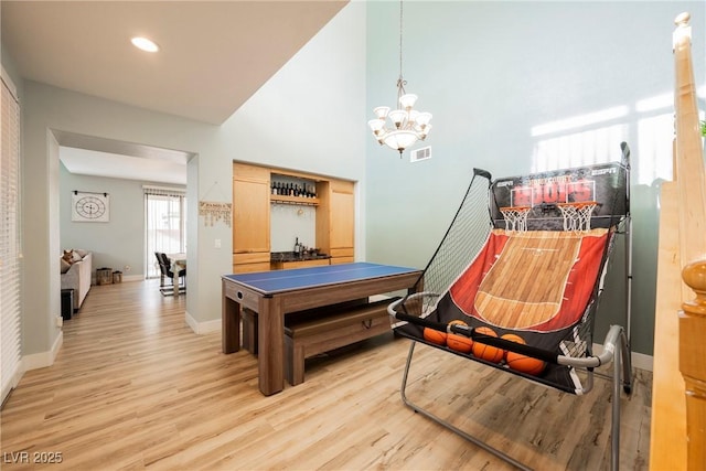 rec room with light wood-type flooring, visible vents, baseboards, and a chandelier