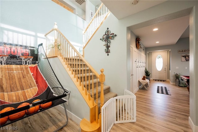 entrance foyer featuring recessed lighting, baseboards, wood finished floors, and stairs