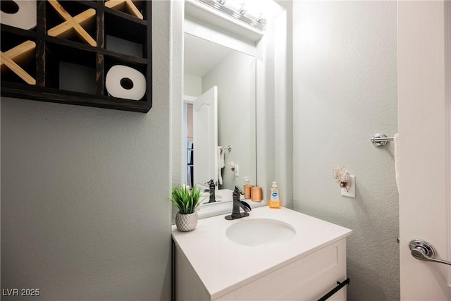 bathroom with vanity and a textured wall