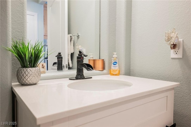 bathroom featuring vanity and a textured wall