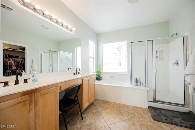 bathroom with visible vents, double vanity, a stall shower, tile patterned floors, and a sink