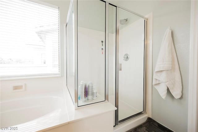 bathroom featuring a bath and a shower stall