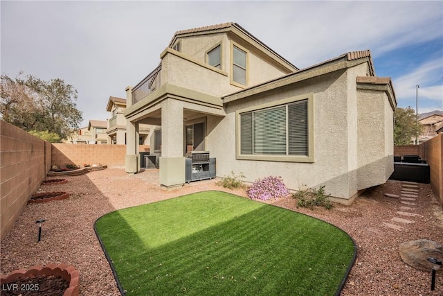 rear view of house featuring a patio, a yard, a fenced backyard, and stucco siding