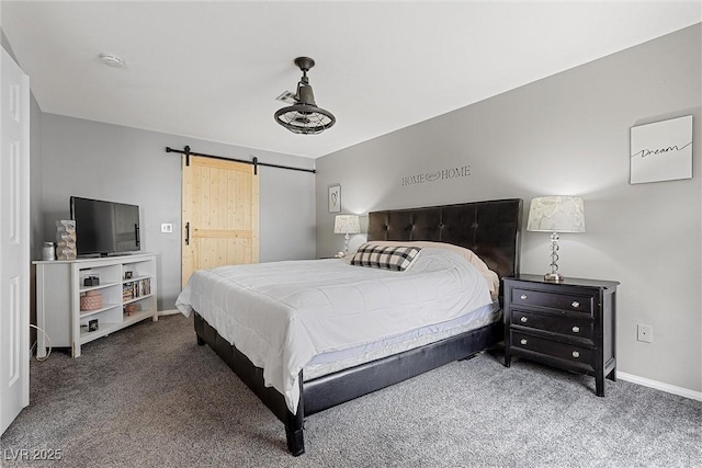 carpeted bedroom with a barn door and baseboards