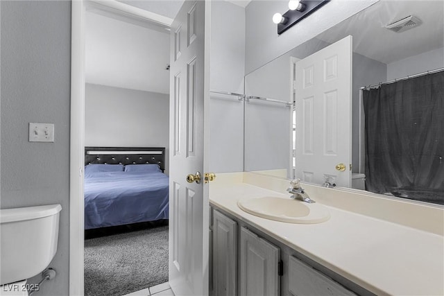 ensuite bathroom featuring vanity, toilet, visible vents, and connected bathroom