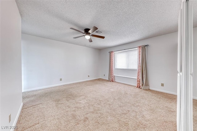 carpeted spare room featuring visible vents, a ceiling fan, baseboards, and a textured ceiling