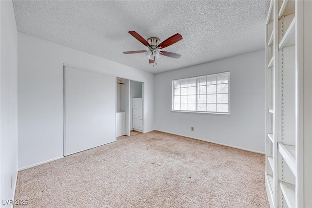 unfurnished bedroom featuring a closet, carpet floors, a textured ceiling, and ceiling fan