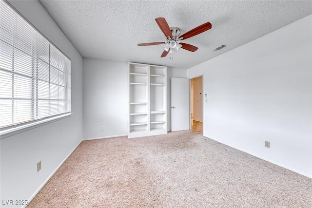 unfurnished bedroom featuring carpet flooring, baseboards, visible vents, and a textured ceiling