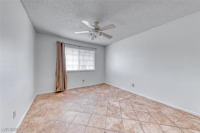 spare room featuring light tile patterned floors, baseboards, a textured ceiling, and ceiling fan