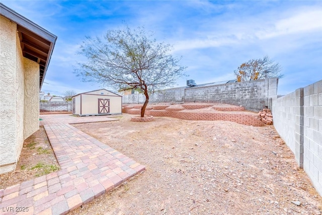 view of yard with a storage shed, a fenced backyard, and an outdoor structure