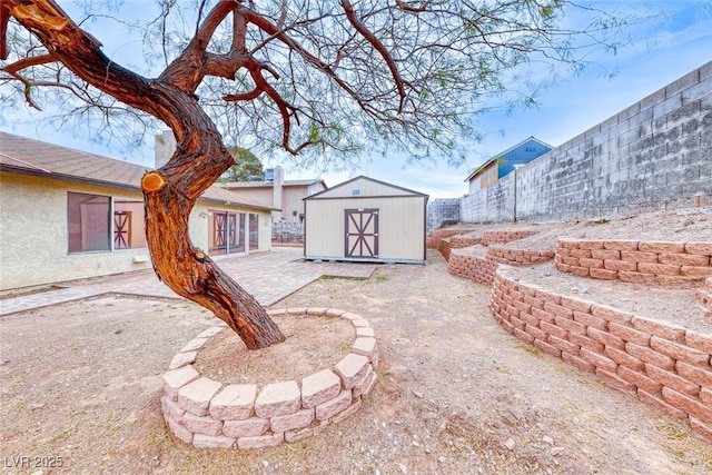 view of yard featuring a patio, an outdoor structure, a fenced backyard, and a shed