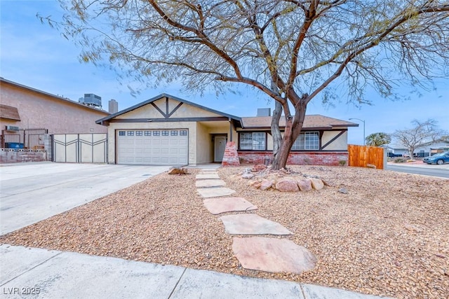 ranch-style home featuring stucco siding, concrete driveway, an attached garage, and fence