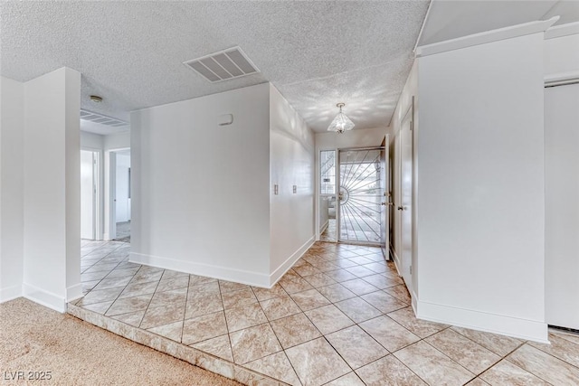 entryway with visible vents, baseboards, a textured ceiling, and a chandelier