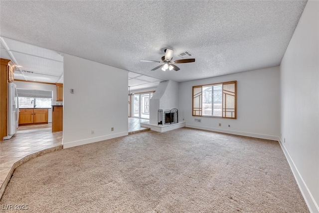 unfurnished living room featuring a ceiling fan, light colored carpet, visible vents, and a multi sided fireplace