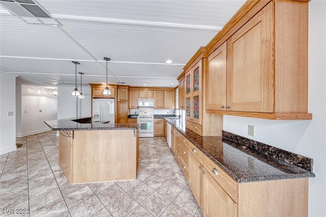 kitchen featuring white appliances, visible vents, a kitchen island, dark stone counters, and glass insert cabinets