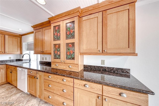 kitchen with a sink, dark stone counters, and white dishwasher