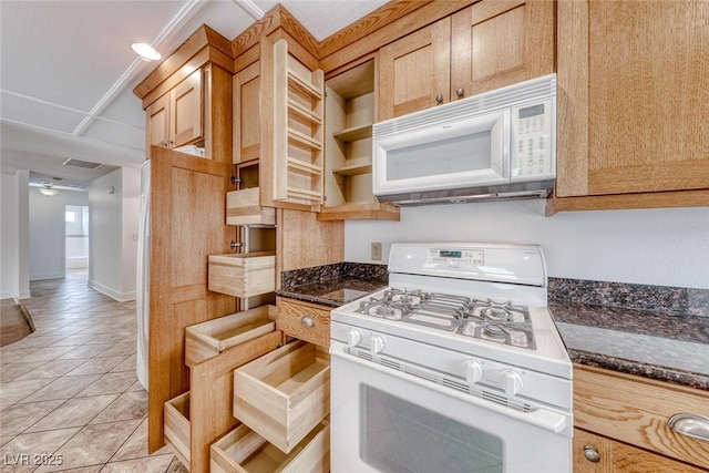 kitchen with white appliances, light tile patterned floors, visible vents, baseboards, and dark stone counters