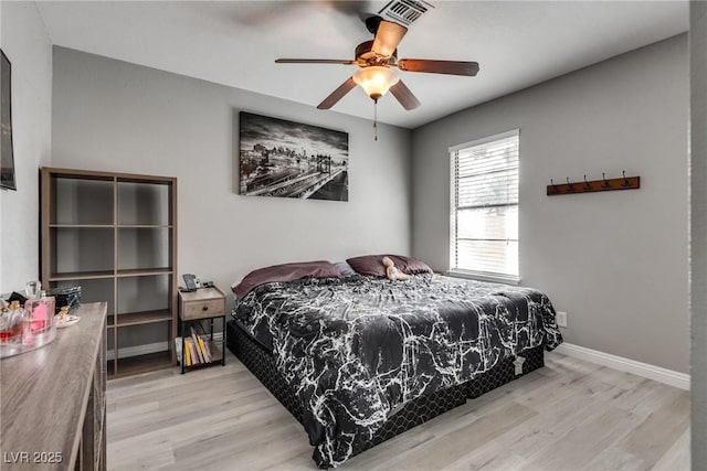 bedroom with ceiling fan, light wood-type flooring, and baseboards