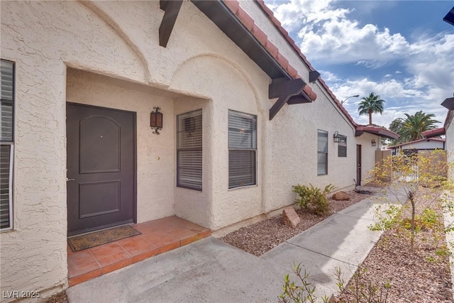 entrance to property featuring stucco siding