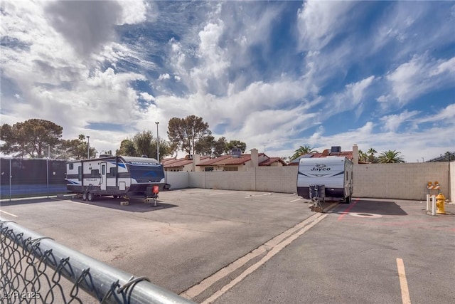 uncovered parking lot featuring fence