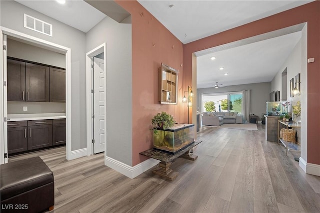 corridor featuring recessed lighting, visible vents, baseboards, and light wood finished floors